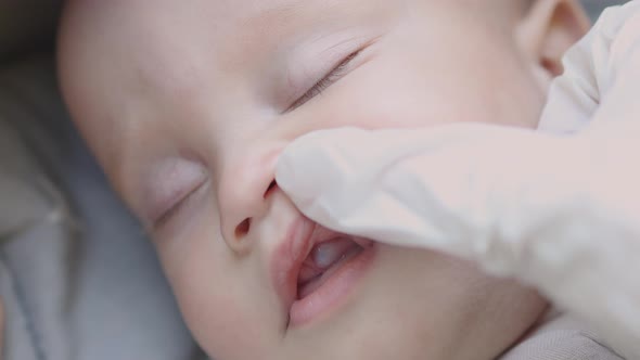 Checking Mouth of a Sleeping Baby with Swollen Blue Gum Milk Teeth Eruption alt