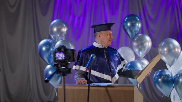Male University Teacher Happily Congratulates Graduates on the End of Academic Year and Presents alt