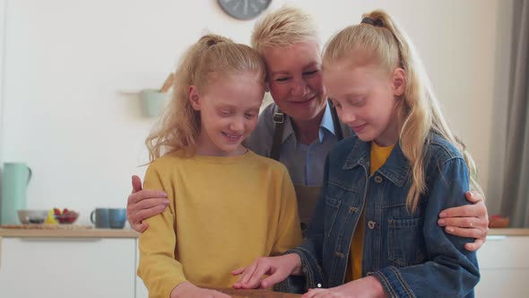 Children Kissing Grandma on Cheeks alt