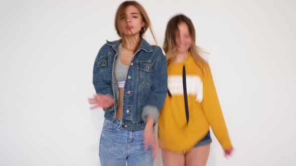 Two carefree young girls going crazy. Women in hipster summer clothes in studio alt