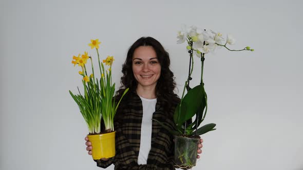 Beautiful Young Woman Florist with Flowers on White Background Smiling at Camera alt