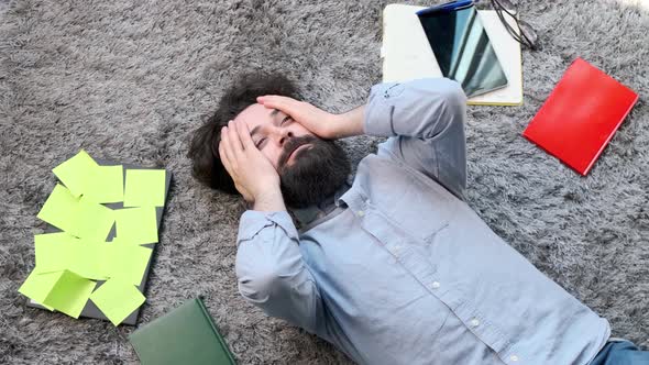Young Man Surrounded By Computer and Documents Very Tired and Exhausted alt