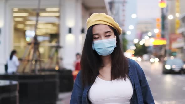 Asian woman standing outdoor wearing protective mask, covid-19 world pandemic alt
