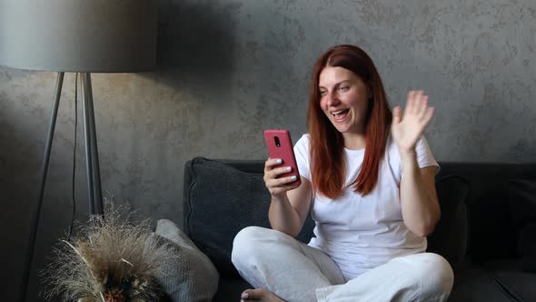 Attractive Woman Smiling Using Video Call on Phone at Home Living Room