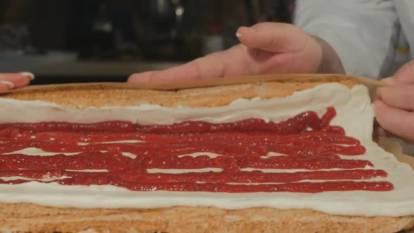 Confectioners Man and Woman Twist a Meringue Roll with Their Hands