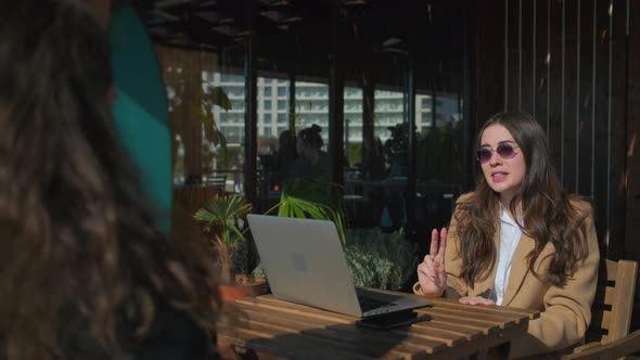 Two Brunette Women Are Talking in Open Terrace in Cafe in Spring Time alt