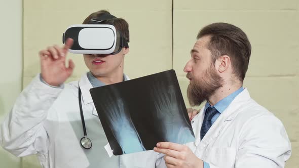 Male Doctor Wearing Vr Glasses, His Colleague Examining X-ray of a Patient alt