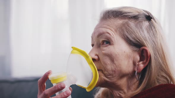 Elderly Lonely Woman Using Oxygen Mask at Home alt