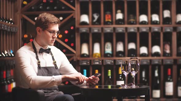 Beautiful Young Sommelier Making Notes in Your Smartphone alt
