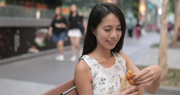 Woman eating Hong Kong famous snack, egg puff alt