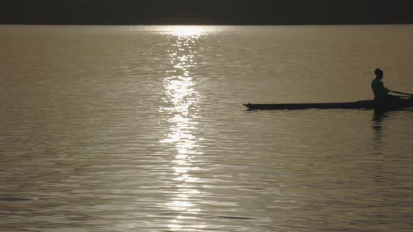 Solo Female Rower on Lake at Sunrise