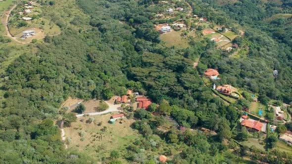 Aerial View of Valley with Farm Field, Forest and Villa in Tropical Country alt