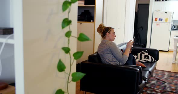 Woman relaxing on sofa and reading book alt