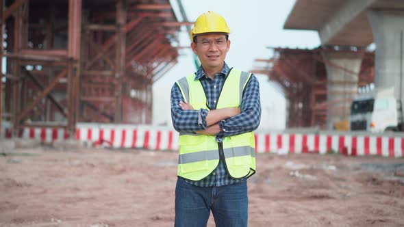 Engineer checking project at a building site, Man in hardhat with arms crossed at the infrastructure