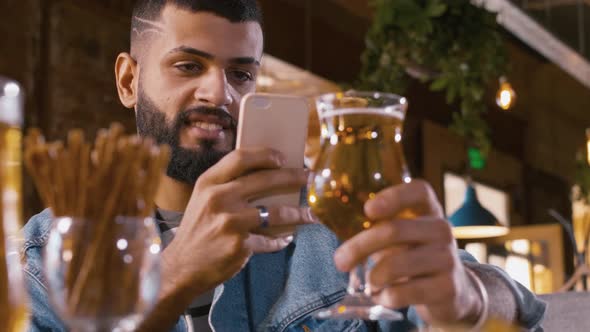 Man taking a picture of beer glass