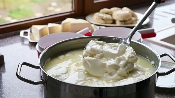 Mixing The Cheese Mass in a Saucepan When Making Homemade Cheese