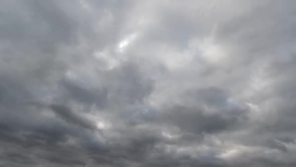 Time lapse: fluffy blue and gray clouds are floating by the sky. alt