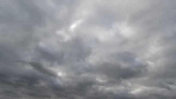 Time lapse: fluffy blue and gray clouds are floating by the sky.