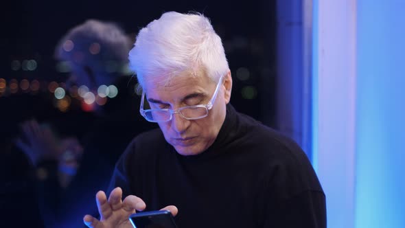 Elderly White Retired Man in Eyeglasses and Turtleneck with Cellphone Texting
