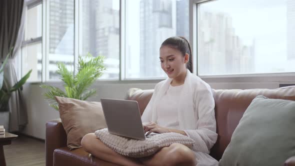 Young asian girl working at a home with a laptop