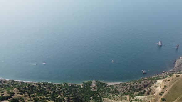 Aerial View From Above on Calm Azure Sea and Volcanic Rocky Shores alt