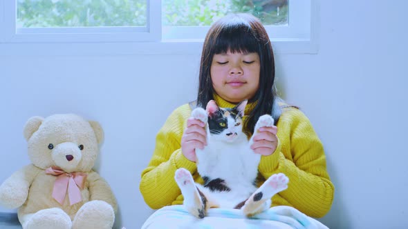 Asian girl sitting with cat at home