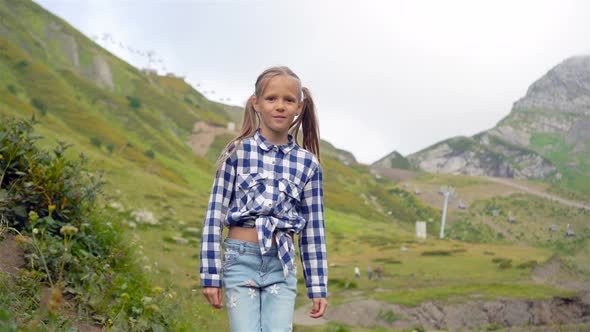 Beautiful Happy Little Girl in Mountains in the Background of Fog alt