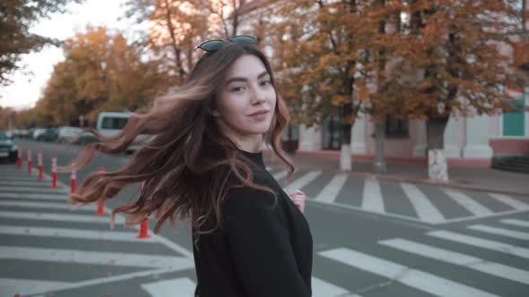 An Elegant Young Girl in a Stylish Black Outfit Crosses the Road at a Pedestrian Crossing and alt