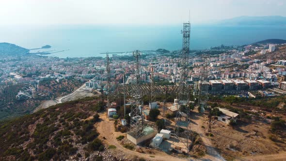 Aerial view of telecommunication communication towers on the mountain near the city. alt
