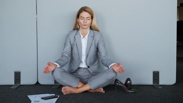Stressful Woman in Lotus Position Sit on the Floor Closed Eyes Meditating alt