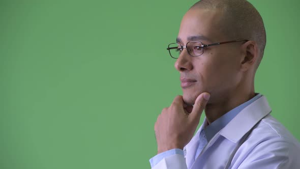 Closeup Profile View of Happy Bald Multi Ethnic Man Doctor Thinking alt