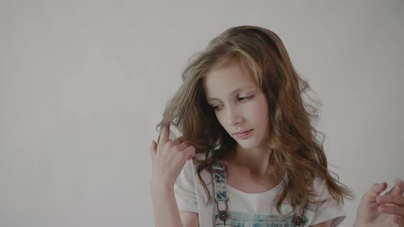 Girl straightens her hair. Portrait of a young girl touching her hair.