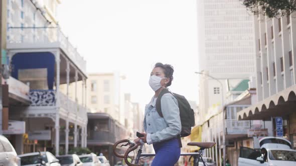 Woman wearing medical coronavirus mask walking on the street alt