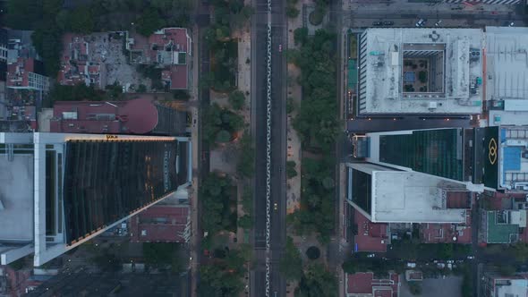 Top Down View of Cars Driving on Road and Tall Building Along Street in Mexico City alt