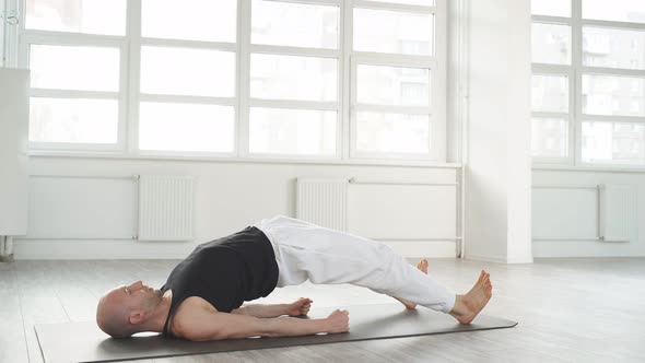 Experienced Bald Caucasian Yoga Man Doing Various Yoga Poses Indoors