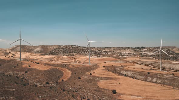 Group Windmills Rotate in Yellow Desert Field