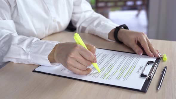 Business Woman Stressing with Green Marker Important Things in Documents Inside