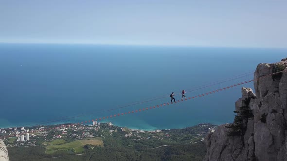 Aerial Shot of Tourists Walking Along Extreme Bridge To the Peak of the Famous Ai-Petri Mountain in alt