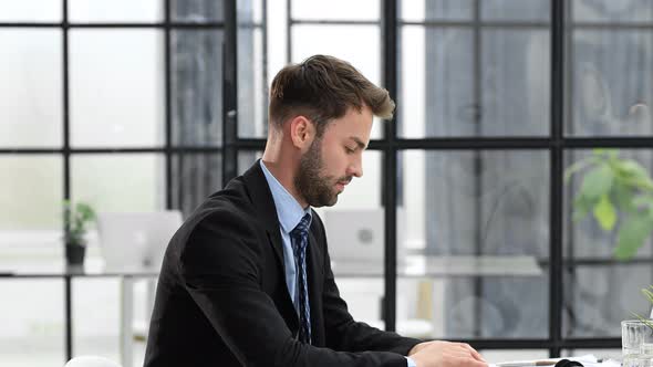 Businessman in a suit enters the office holding out his hand for a handshake. alt