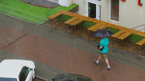 Wet Man in the Street. People Are Trying To Escape From the Elemental Rain alt