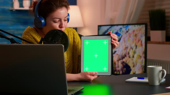 Influencer Holding Tablet with Green Screen Speaking During Podcast alt