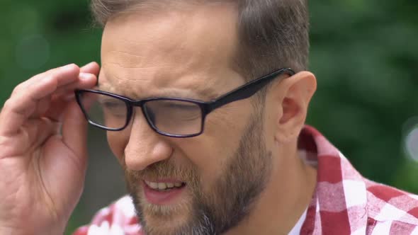 Male Taking Off Glasses and Massaging Temples, Headache, Needs Painkillers alt