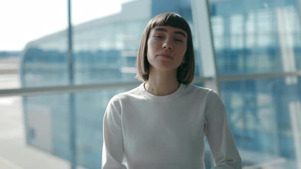 Portrait View of the Young Calm Short Haired Single Woman Standing Arms Crossed and Looking at the alt