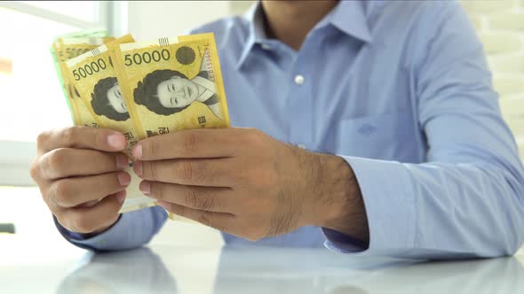Businessman counting money, South Korean Won banknotes
