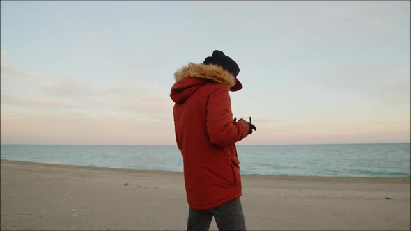 Young boy pilots drone at the beach alt