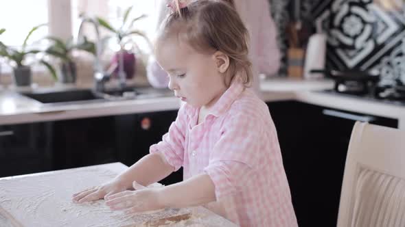 Little Girl Cooking with Caring Mother at Kitchen