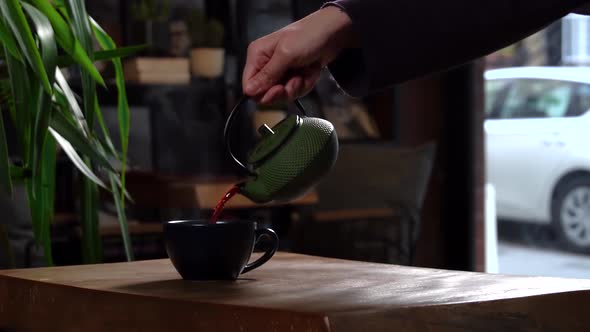 Cinematic Slow Motion Pouring Herbal Tea in Navy Blue Mug from Green Tea Pot alt