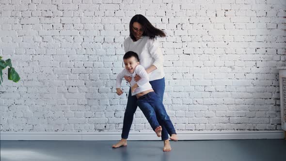 Happy Family Loving Young Mum Playing Piggybacking Cute Little Funny Kid Daughter Sit on Couch at alt