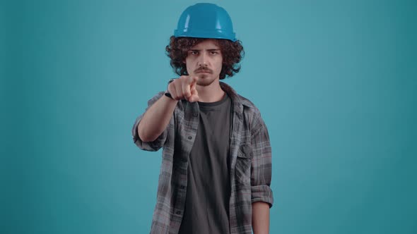 The Charismatic Serious and Frowning Young Man Points with His Index Finger in Front of His Head and alt