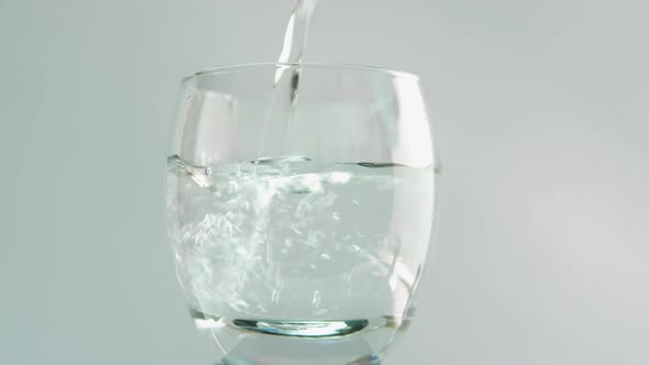 Drinking Water In A Glass On A White Background. Pour Water Into A Transparent Glass Close Up.